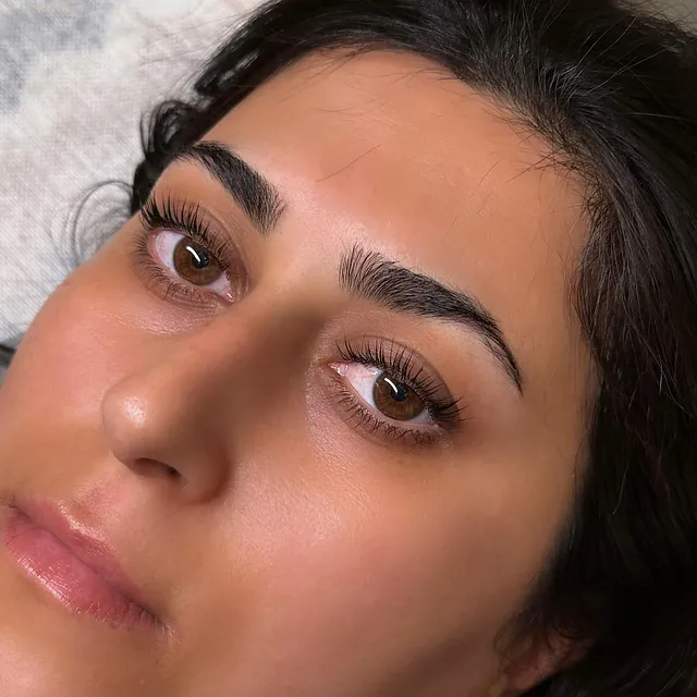 Kvinne med mørke bryn og naturlige vipper etter behandling.