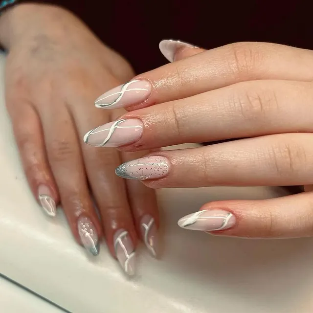 Negler med spiss form dekorert med hvite striper og sølvdetaljer.
