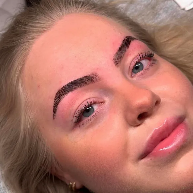 Kvinne med nyformede mørke bryn og naturlige vipper etter behandling.